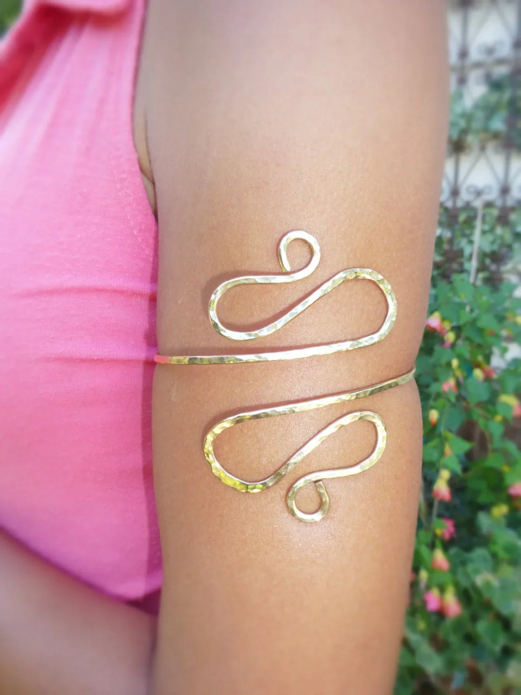 Gold arm band on a person's arm with a blurred background